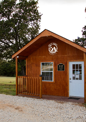 Peaceful RV sites surrounded by trees at Queen & Duke RV Resort in Whitesboro, Texas